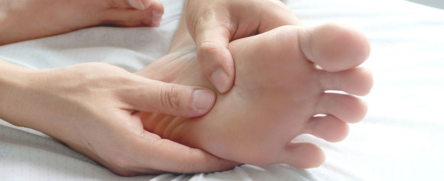 Person holds their foot in pain