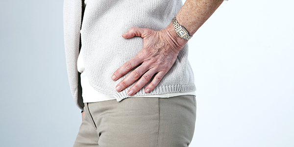 Photograph of woman holding hip effected by bursitis.