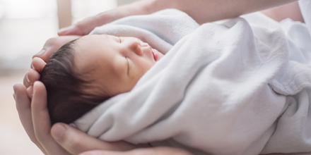 photograph of an infant in a blanket