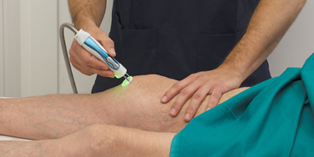 photograph of a physiotherapist performing laser therapy for pain relief