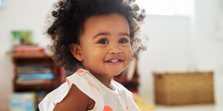 photograph of a smiling toddler in a physiotherapy clinic