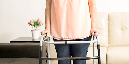 photograph of a woman using a walker fit by a physiotherapist