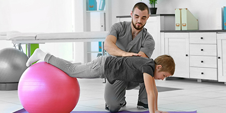 photograph of a young boy performing physiotherapy exercises